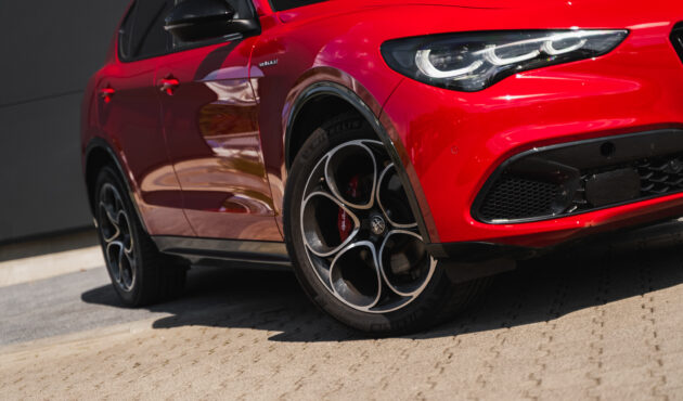 Alfa Romeo Stelvio przód, charakterystyczny grill Trilobo, reflektory LED Matrix na drodze.