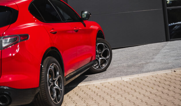 Alfa Romeo Stelvio profil, dynamiczna sylwetka premium, SUV na malowniczej trasie.