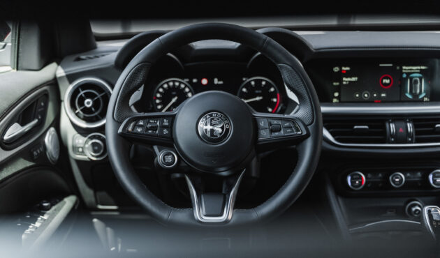 Wnętrze Alfa Romeo Stelvio, skórzana tapicerka premium, cyfrowe zegary, luksusowy kokpit.