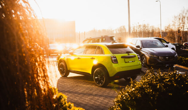 Nowy Fiat 600 Hybrid Sport 145 KM w jaskrawym limonkowym kolorze zaparkowany pod salonem samochodowym Waro.