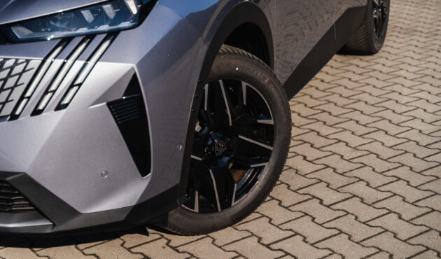 Zbliżenie na przód i alufelgę nowego Peugeota 5008 w kolorze srebrny metalik przed salonem Waro w Bielsku-Białej.